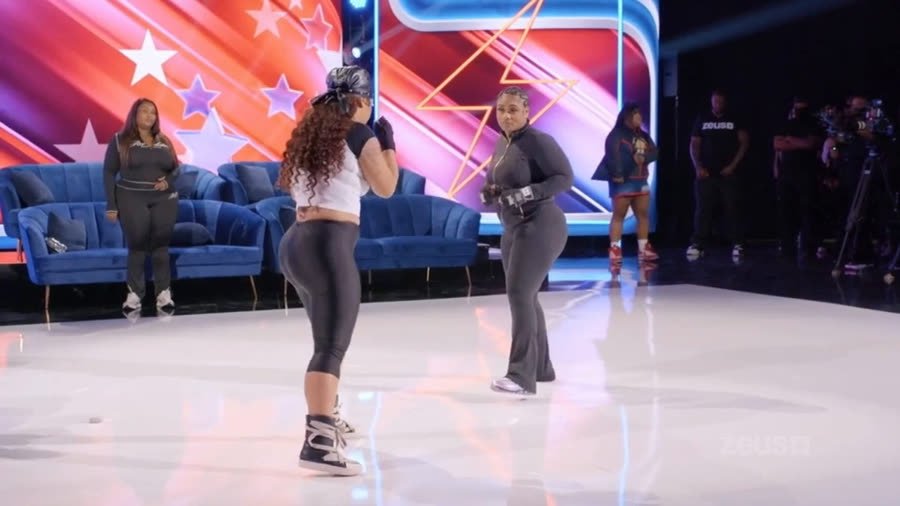 Two cast members facing off in boxing gloves on the reunion stage floor
